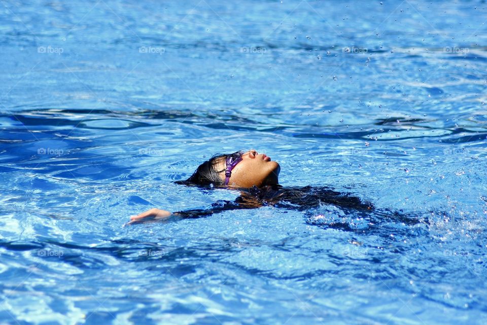 boy floating in a swimming pool