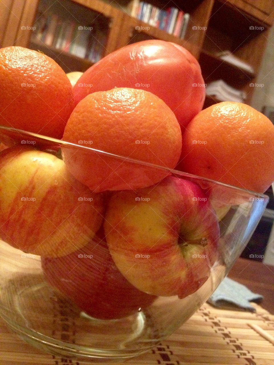 Apples and oranges in a glass bowl on a stand