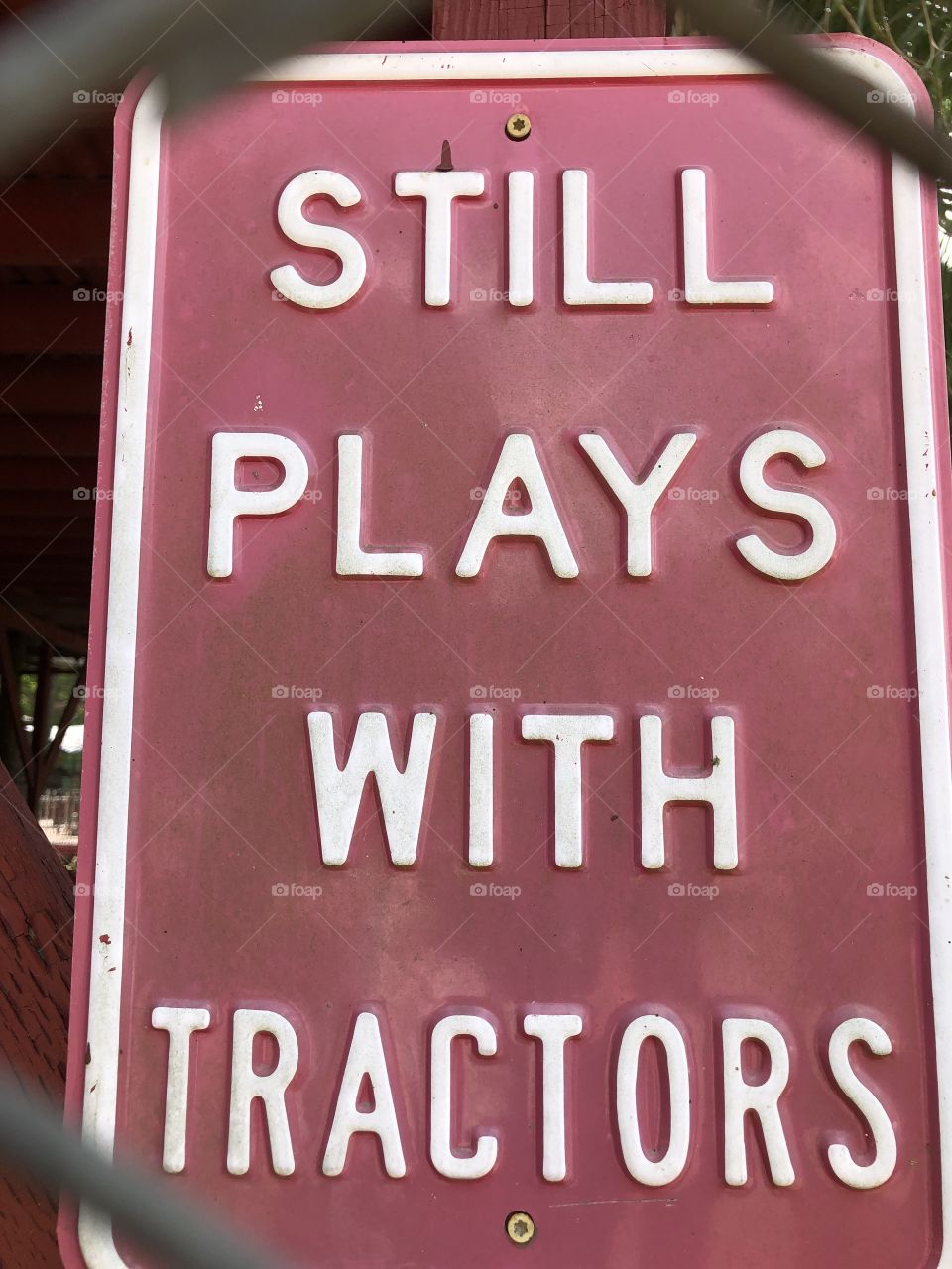 "Still plays with tractors" sign 