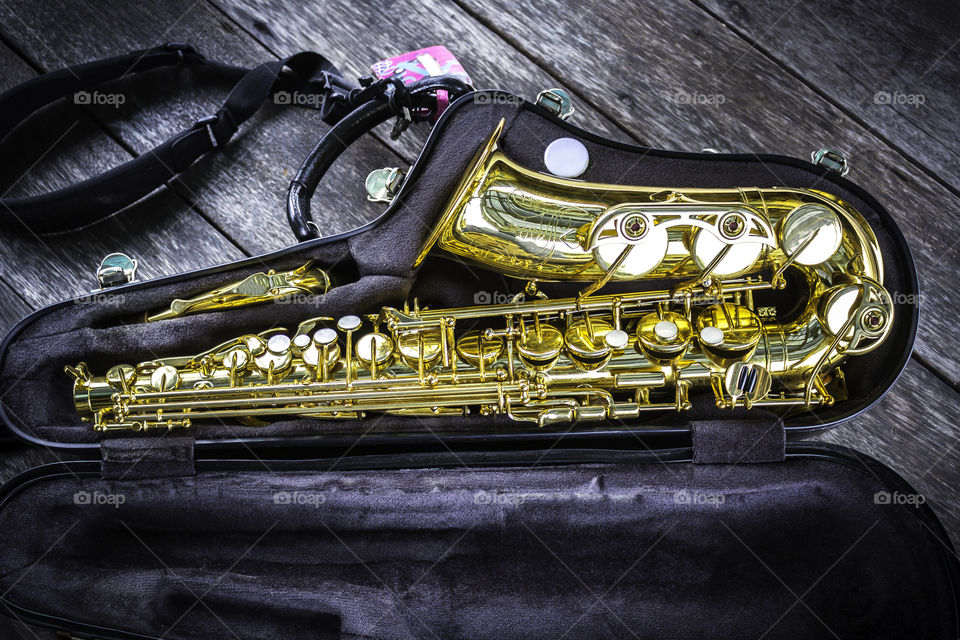 Part of golden alto saxophone in box