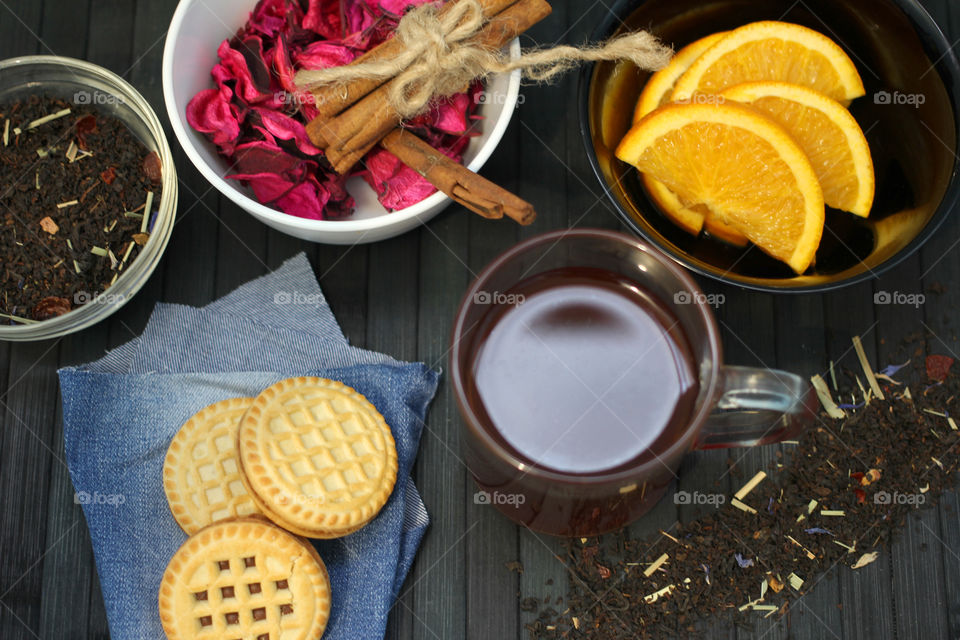 Tea tradition, tea, cup, mug, hot drink, cinnamon, cookies, napkin, jeans, denim napkin, fruit tea, flower tea, citrus, orange, lemon, rose petals, cookies, chocolate cookies, vanilla, vanilla sticks