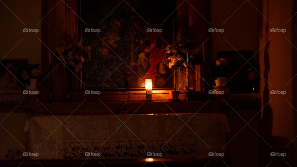 Lonely candle burning in a little church