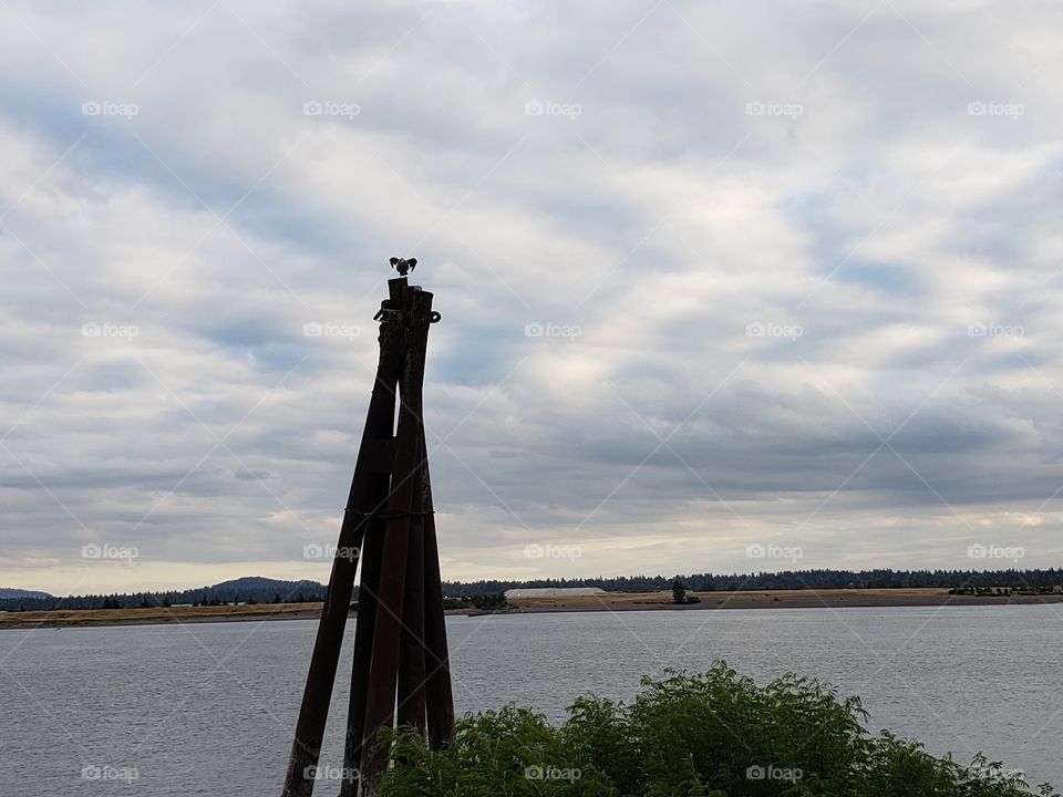 Wooden post and river on a cloudy day