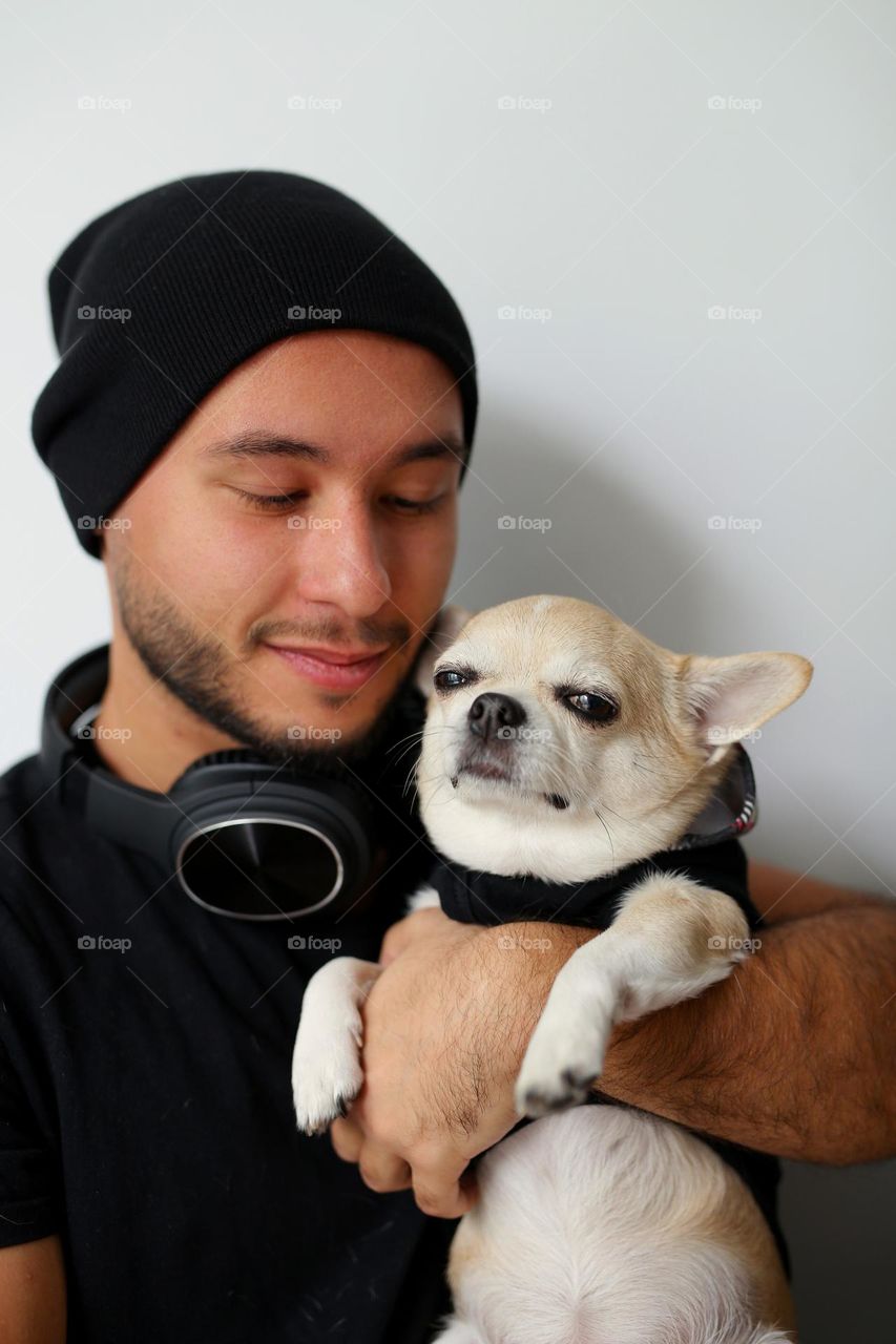 stylish guy in black clothes, with headphones and his best friend, a dog. a twenty-three-year-old teenager, a new generation.