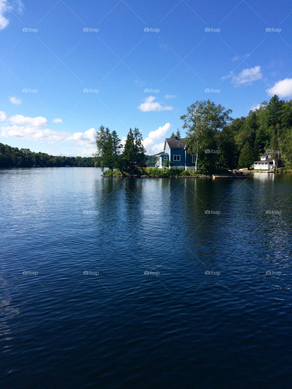 A small house on an isle is waiting for a boat to come.
