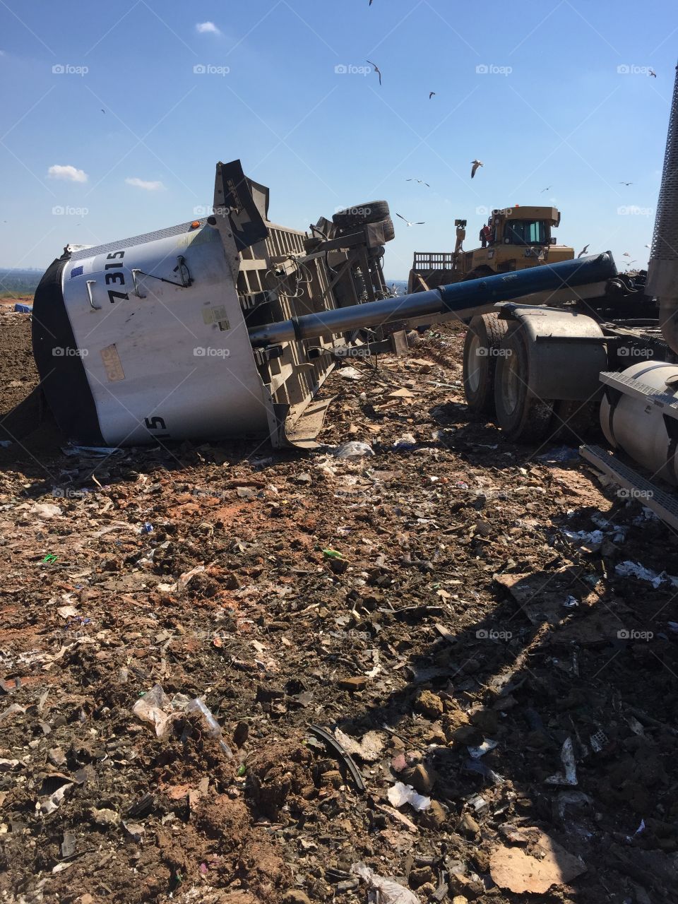 Republic Services tractor trailer in McCarty Landfill with a rolled over trailer 
