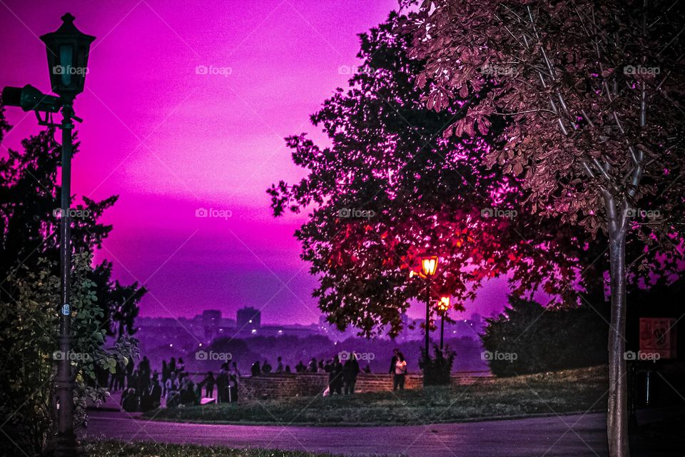 People watching a sunset on a landscape of a city