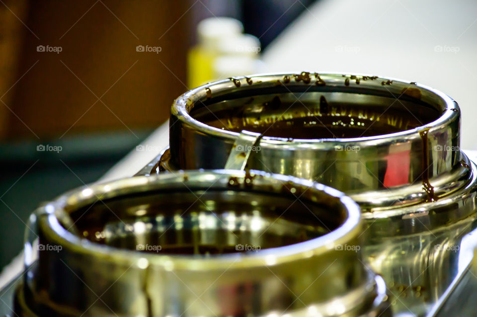 Rich dark chocolate sauce for melted chocolate ice cream dip in containers conceptual food service and dessert photography background with room for copy