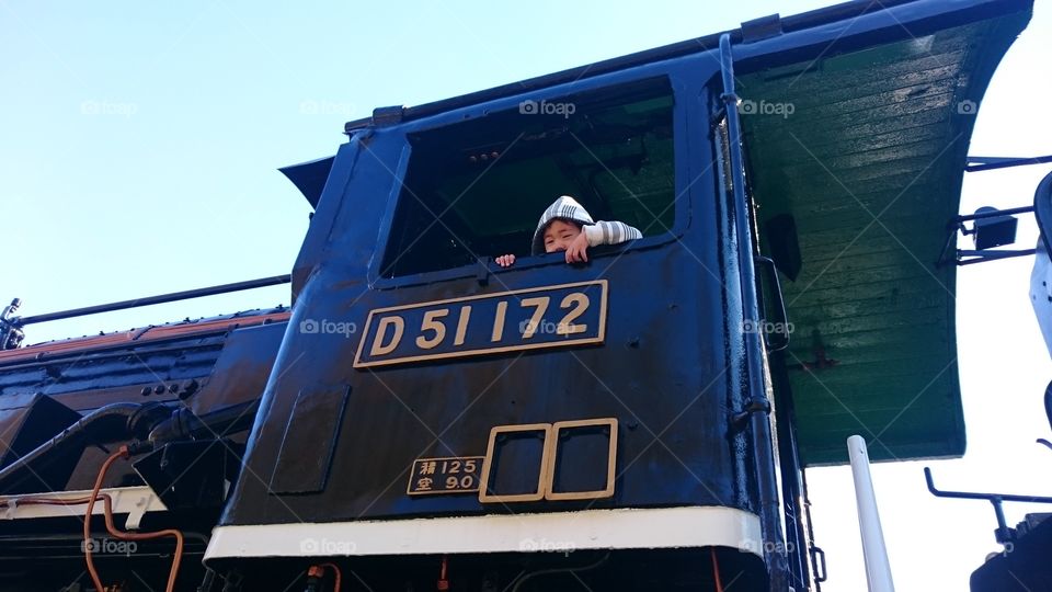 Asian boy sitting in locomotive train