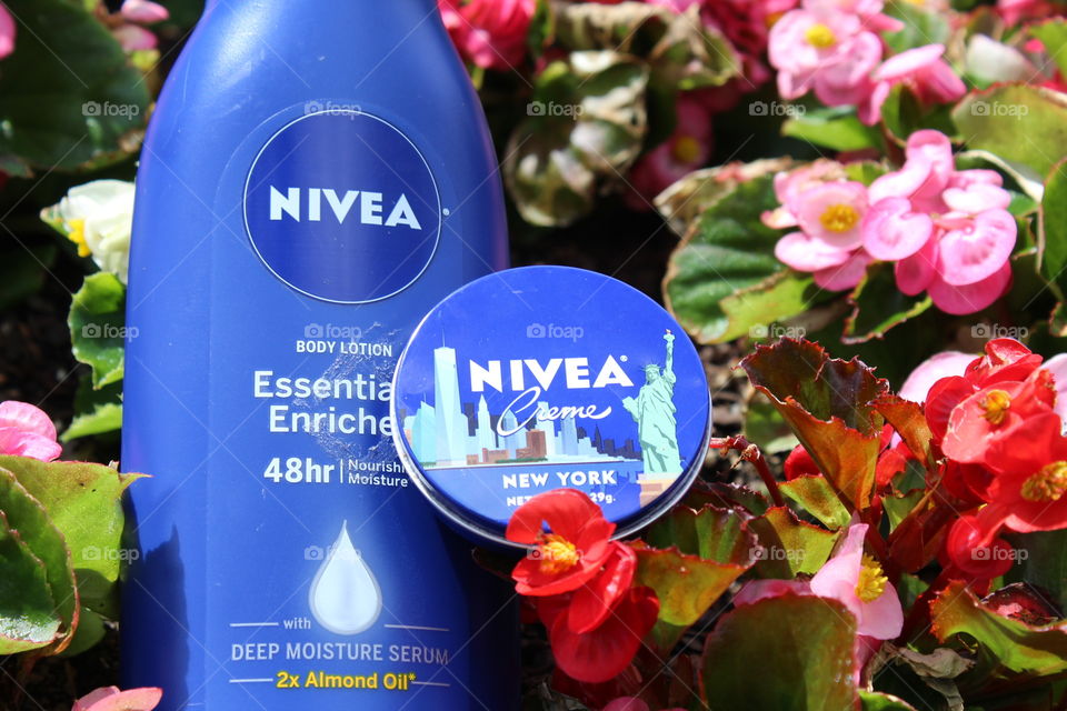 Nivea Lotion against a natural floral background, with red, pink, and green accents