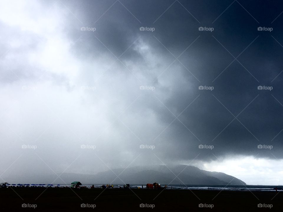 The rain is coming ... look at the heavy clouds approaching the beach.  There is plenty of water here at Santos beach! / A chuva vem chegando... olhe aí as nuvens carregadas se aproximando da praia. Vem bastante água aqui na praia de Santos!