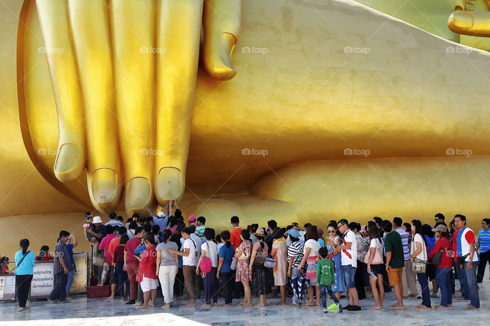 Peoples touch big buddha's finger for pray on impotant days