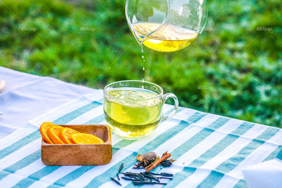 Close-up of jug pouring green tea in cup