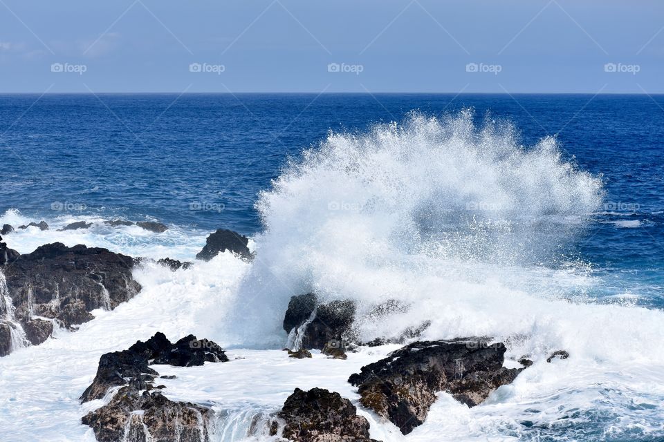 A big splash on a lava rock outcropping on the east side of the Big Island of Hawaii.