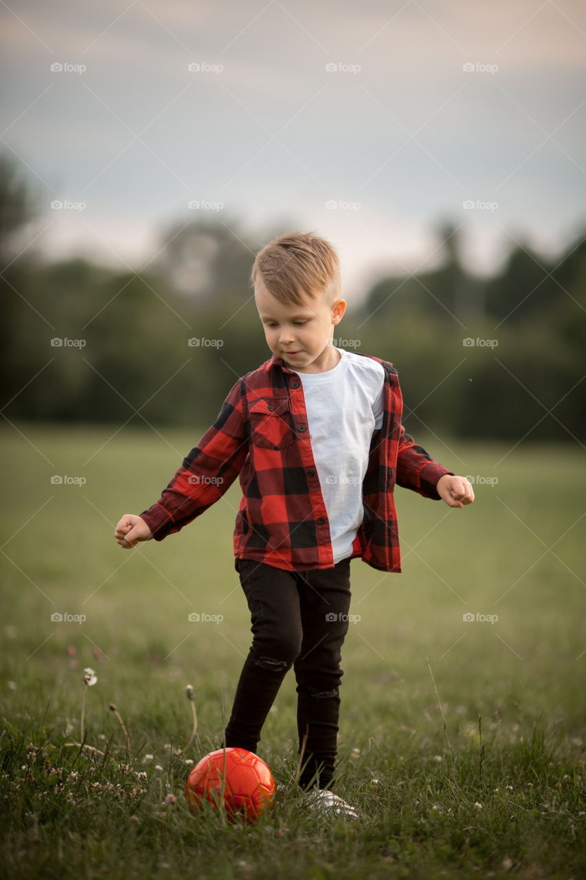 Little boy playing in soccer in a park 