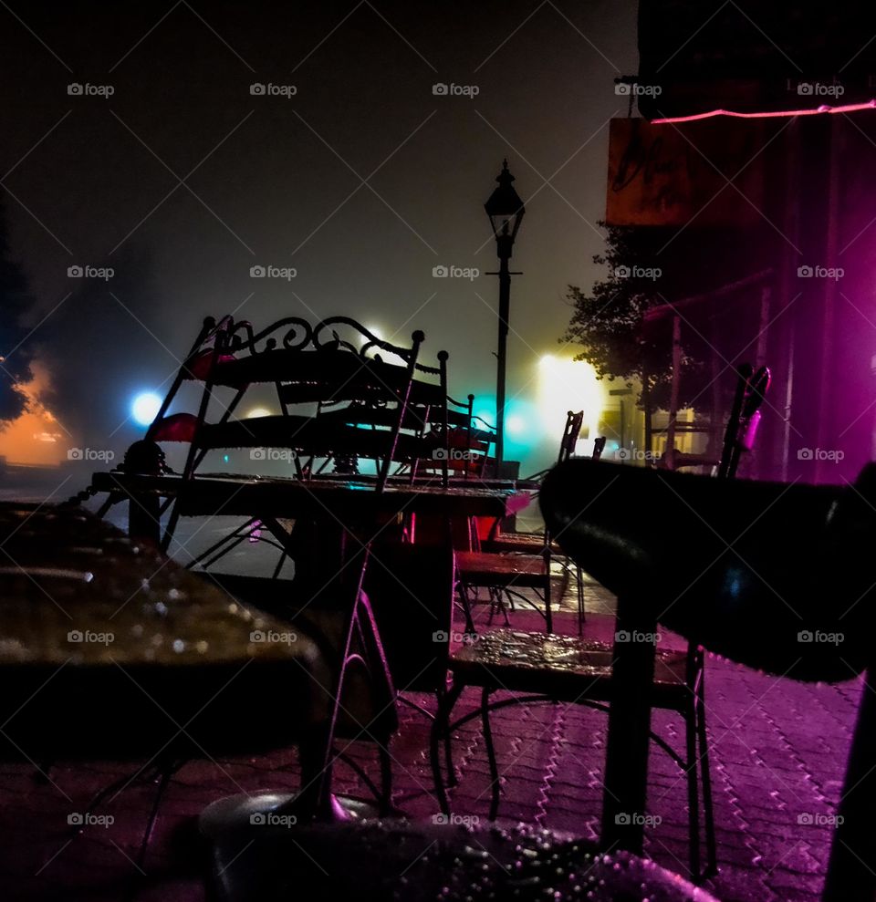 Cafe tables at night bathed in magenta neon light