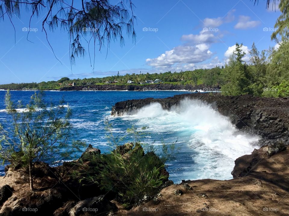 Wave hitting a black sand beach