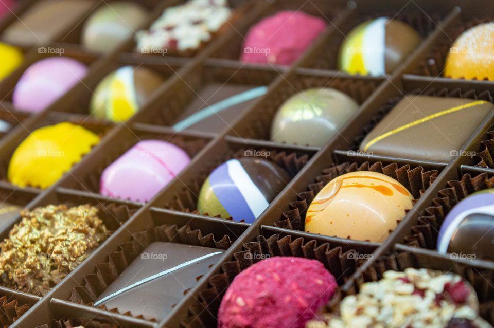 Color glaze on chocolate sweets in packaging handmade candy