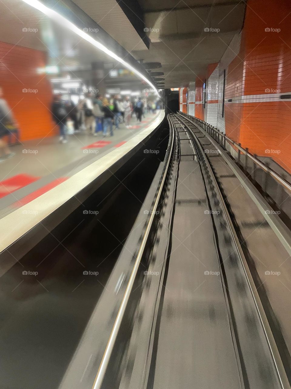 View through the window of a driverless subway to people waiting on the platform