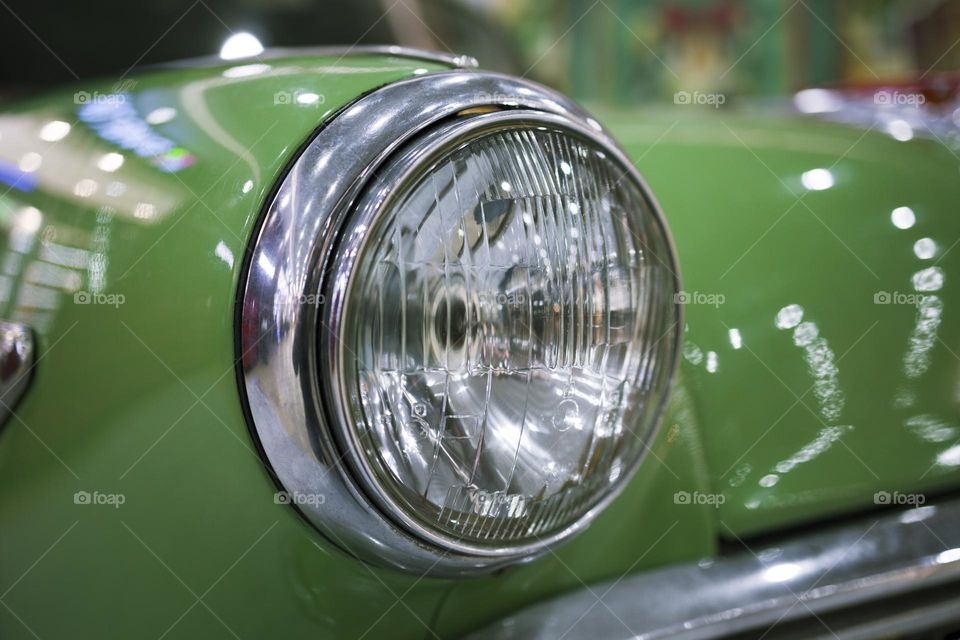 Close up old vintage green car headlight chrome