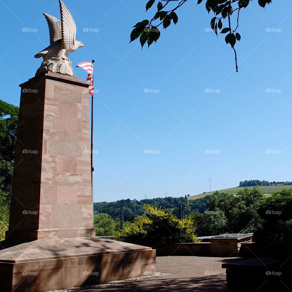 A beautiful outdoor memorial with a waving American Flag in Luxembourg on a sunny summer day. 