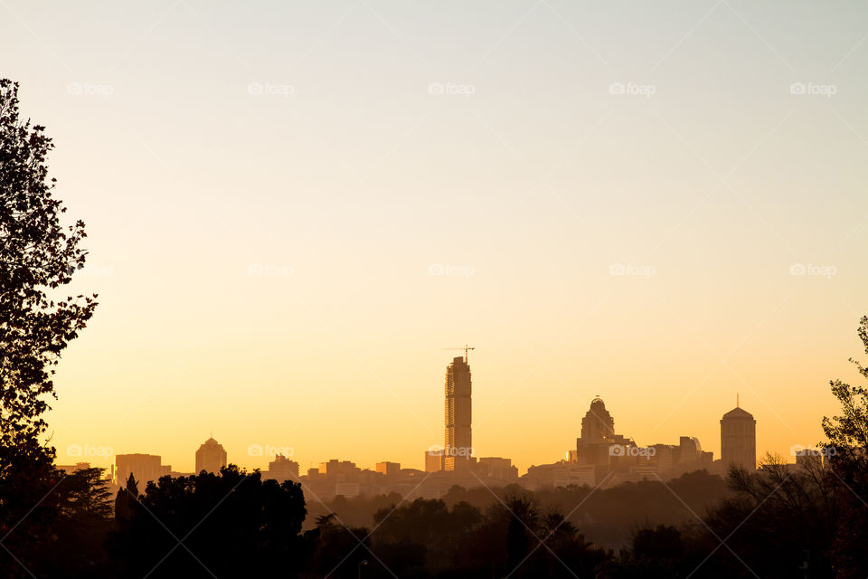 Sandton skyline in Johannesburg at sunrise. Yellow and golden light on the buildings.