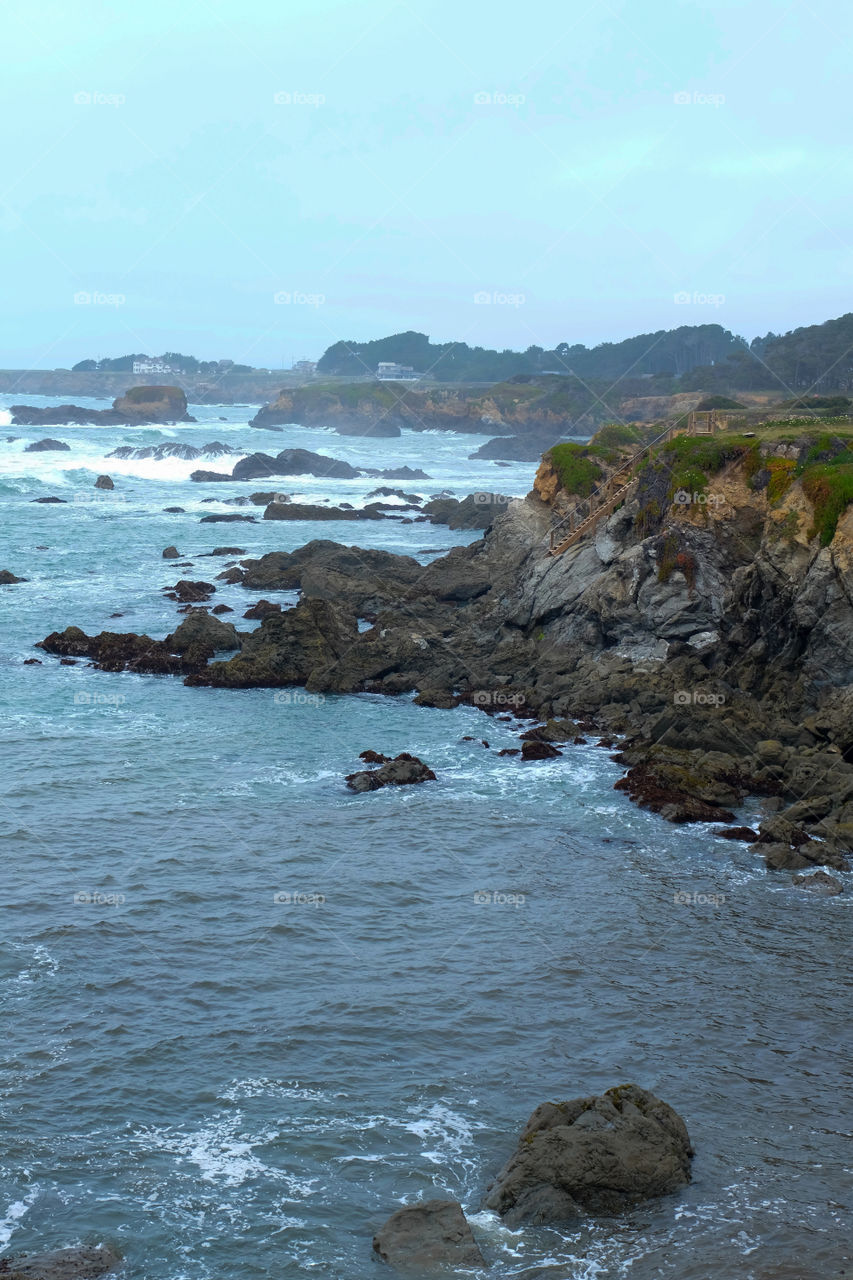 Rocky Pacific coast, waves crashing, wooden stairs