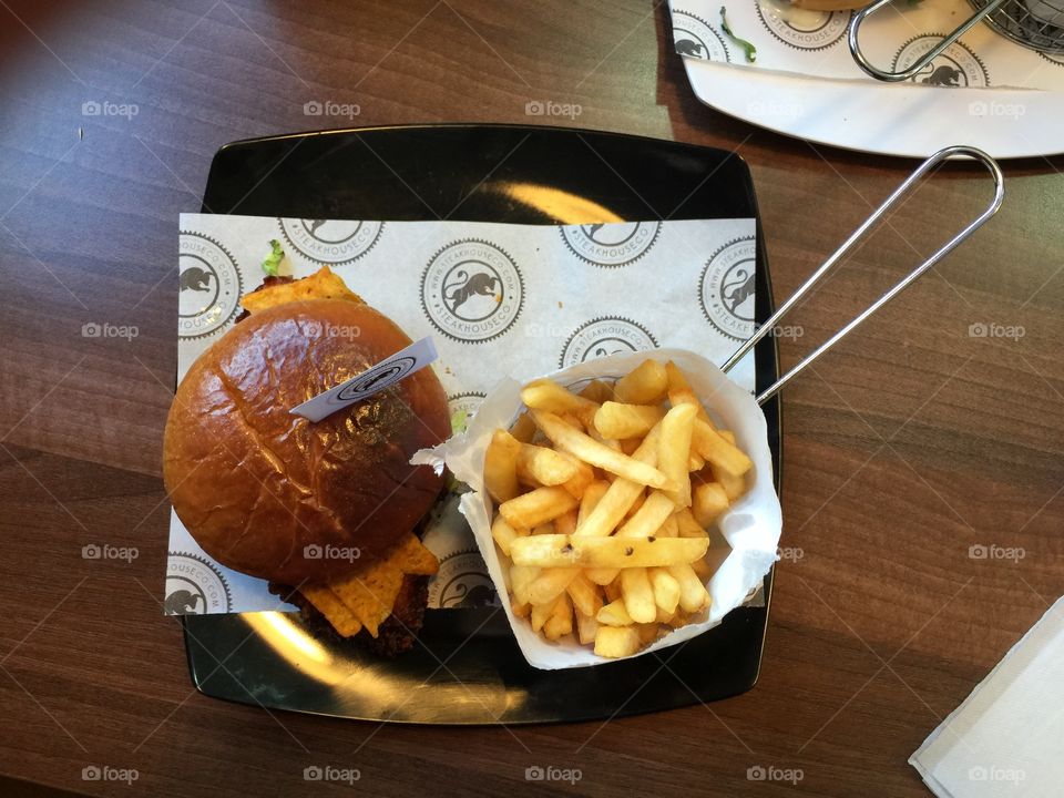 Burger and french fries in plate on table