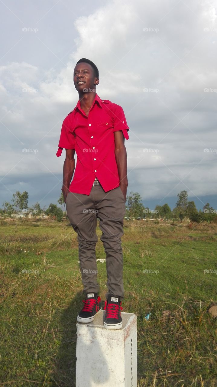 African boy standing on concrete post