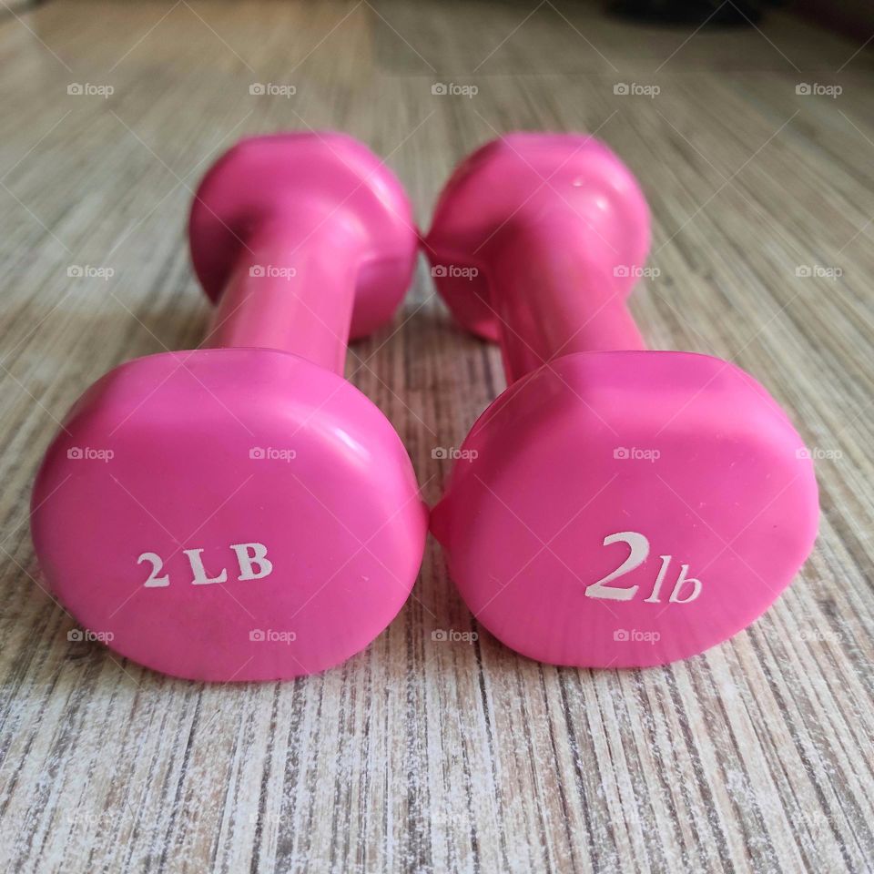 Two pink dumbbells lie on the table