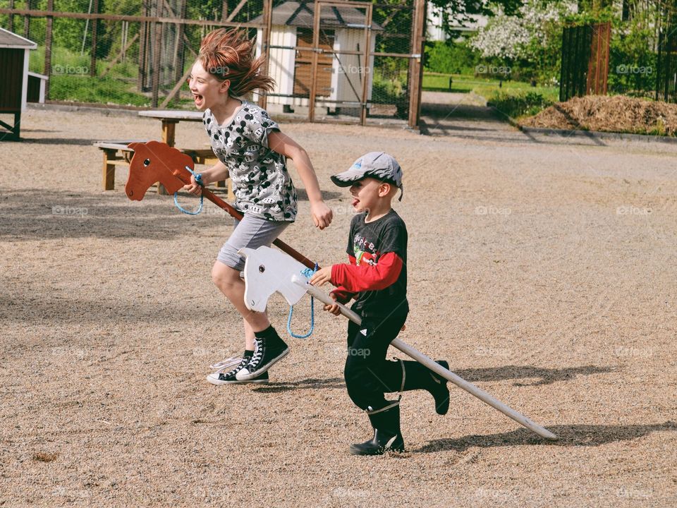 Children playing with hobbyhorses