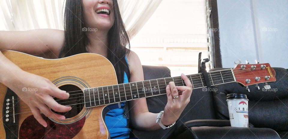 A lady having fun while playing the guitar.