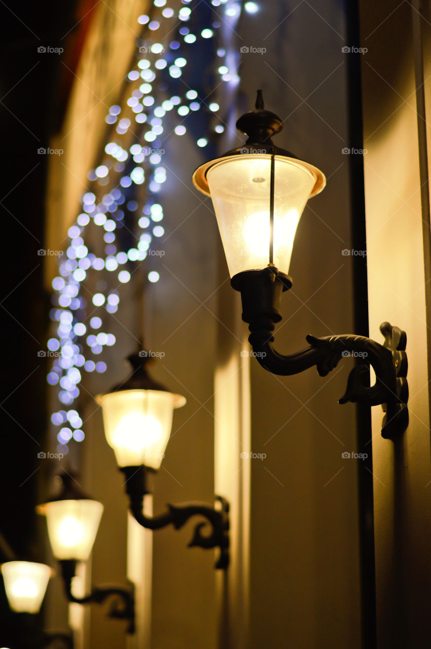 Lantern, street lamp and Christmas blue garland in night city