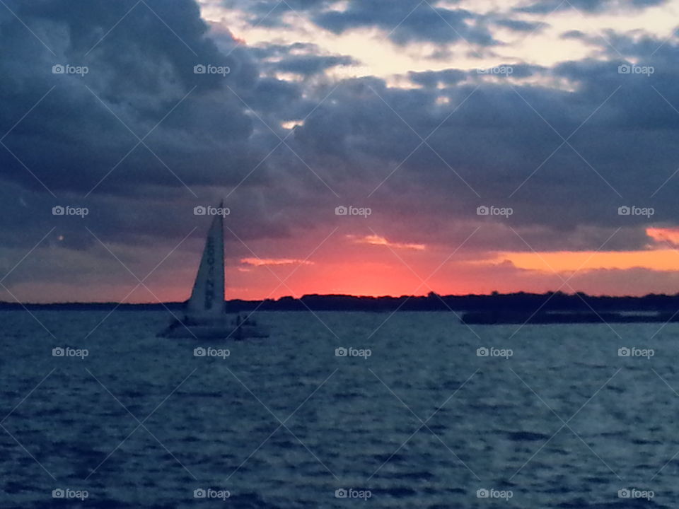 sunset behind sail boat