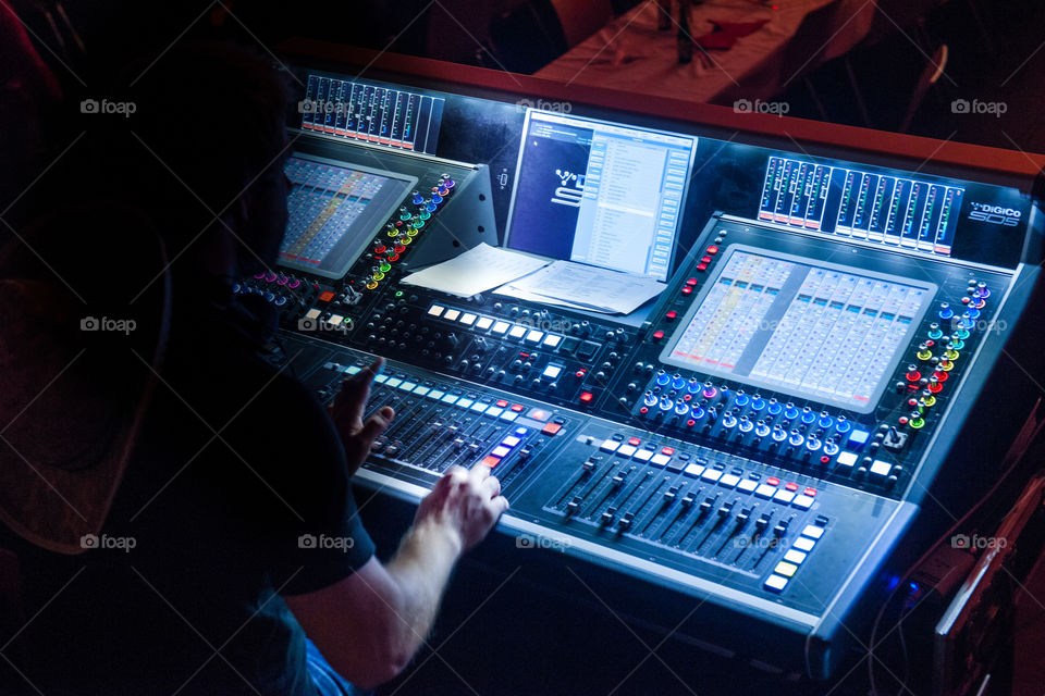 lighting technicians, sound technicians working at a mixing board in a big event.