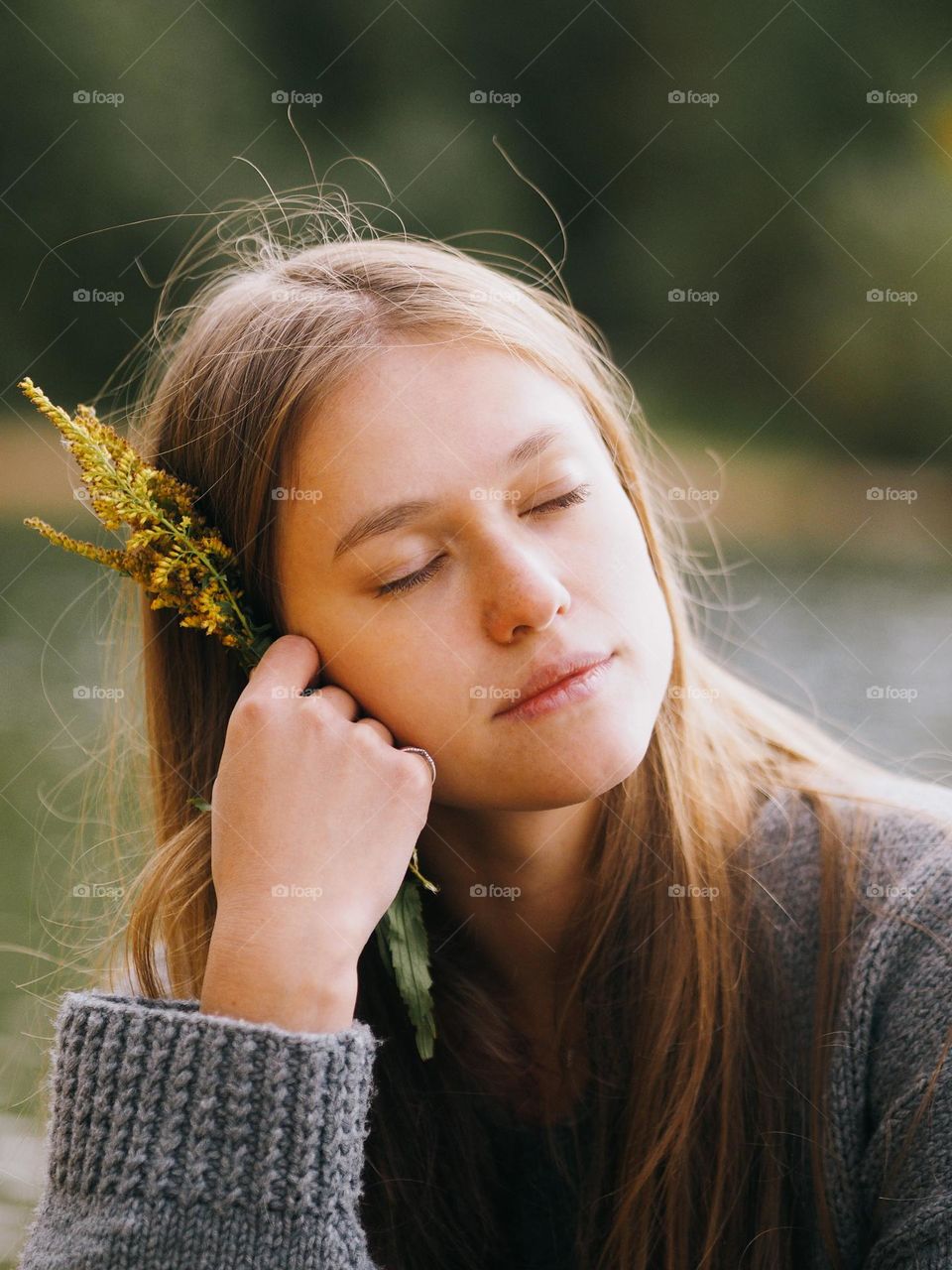 Portrait of young beautiful woman with long hair with closed eyes on a nature, glimmers 