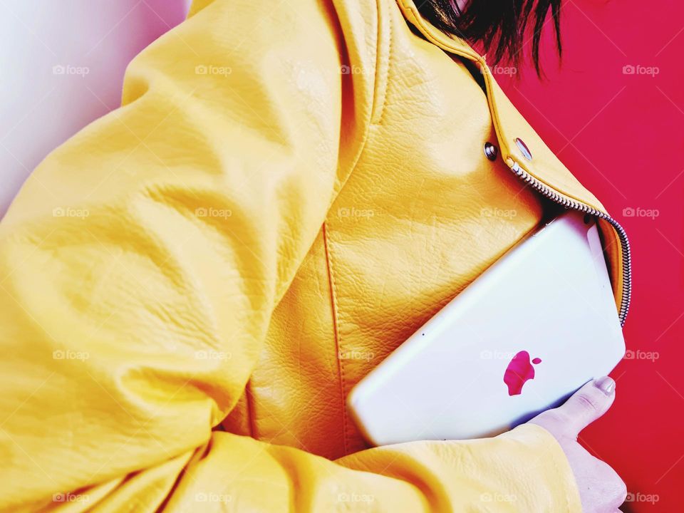 woman in yellow vest carries her Ipad under her arm