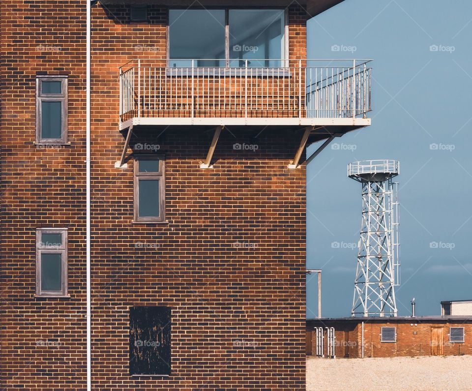 Brick buildings and metal structures on the stones at Dungeness, UK 