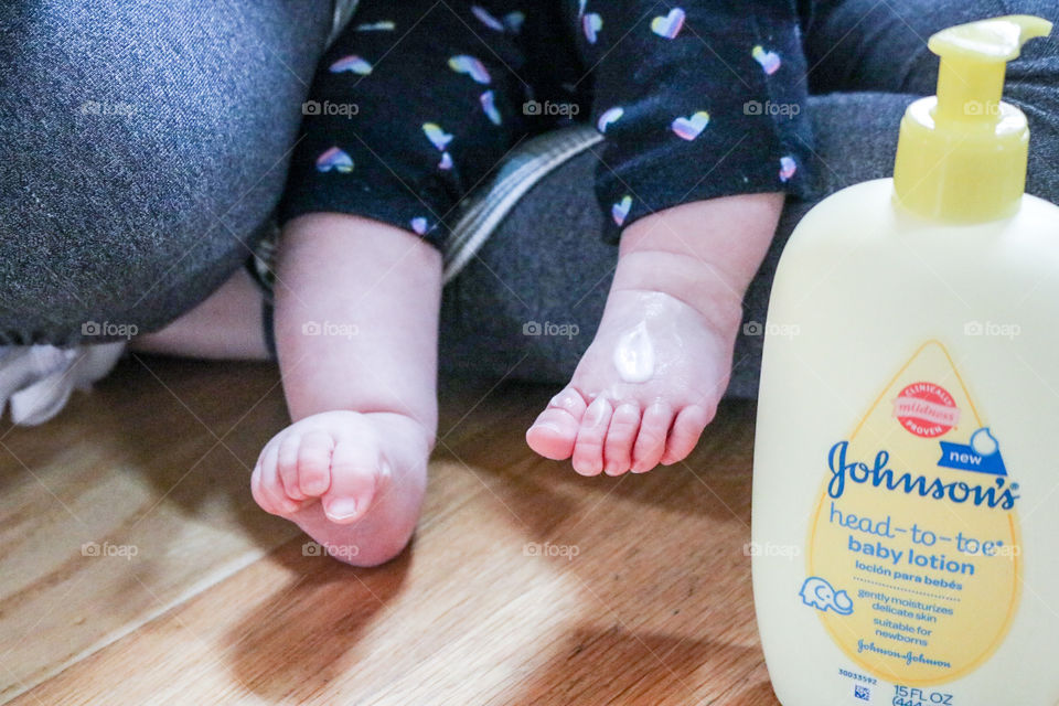 Baby care with Johnson’s- lotion on little toes.