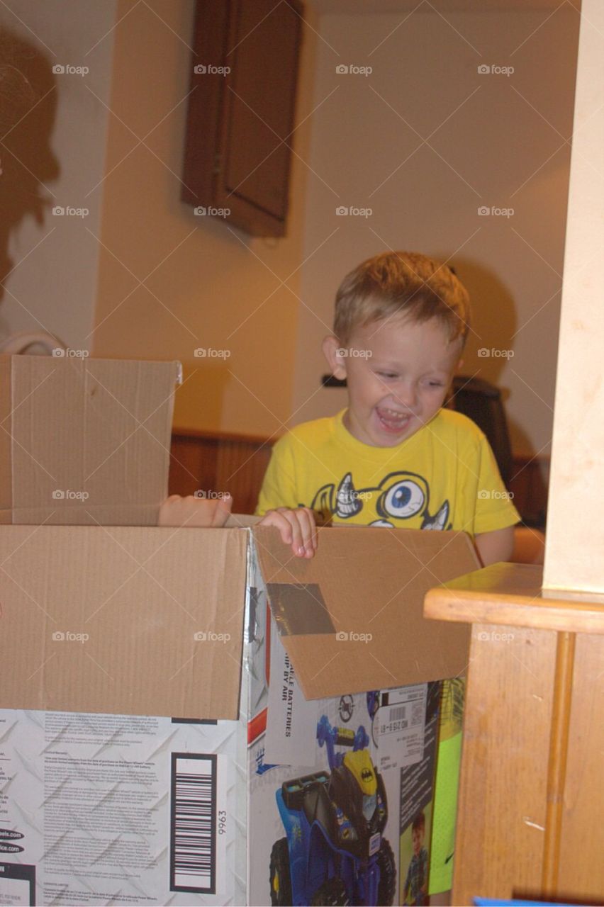 Smiling boy standing near cardboard box