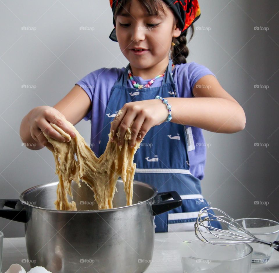 Cute little girl is helping in the kitchen