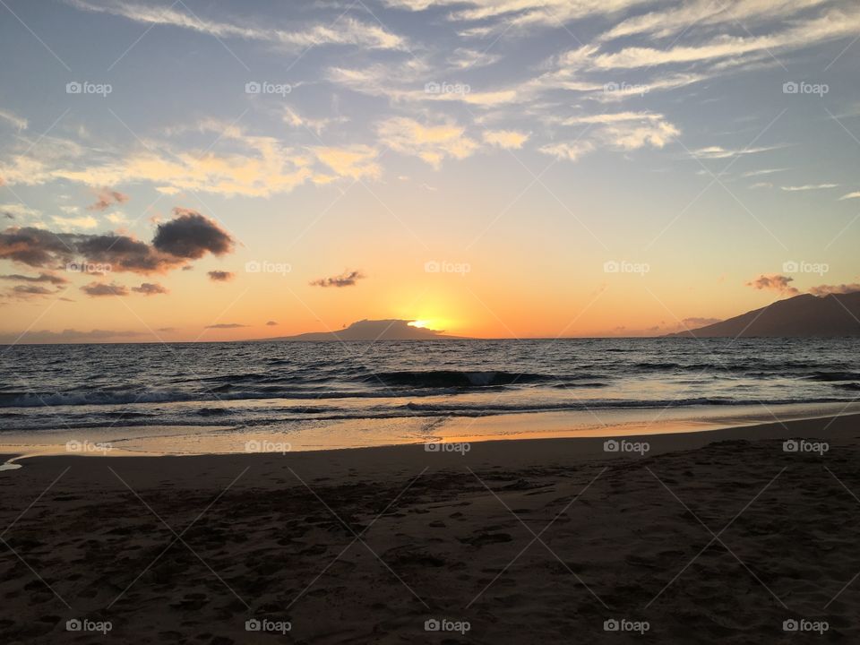 Scenic view of sea against dramatic sky at sunset