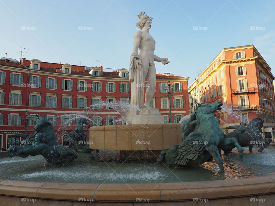 Sun fountain with statue of Apollo and mythological bronze figures on the Place Massena in Nice, France.