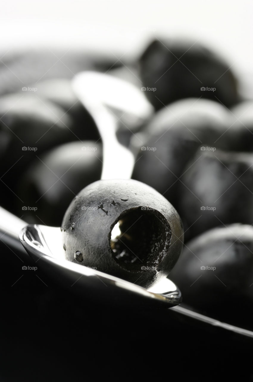 Close up photo of olive on spoon