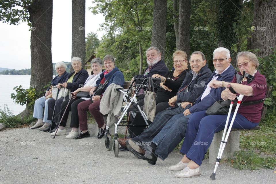 Elderly People. Elderly people sitting on bench facing the lake Sempachersee in Luzern,Switzerland.