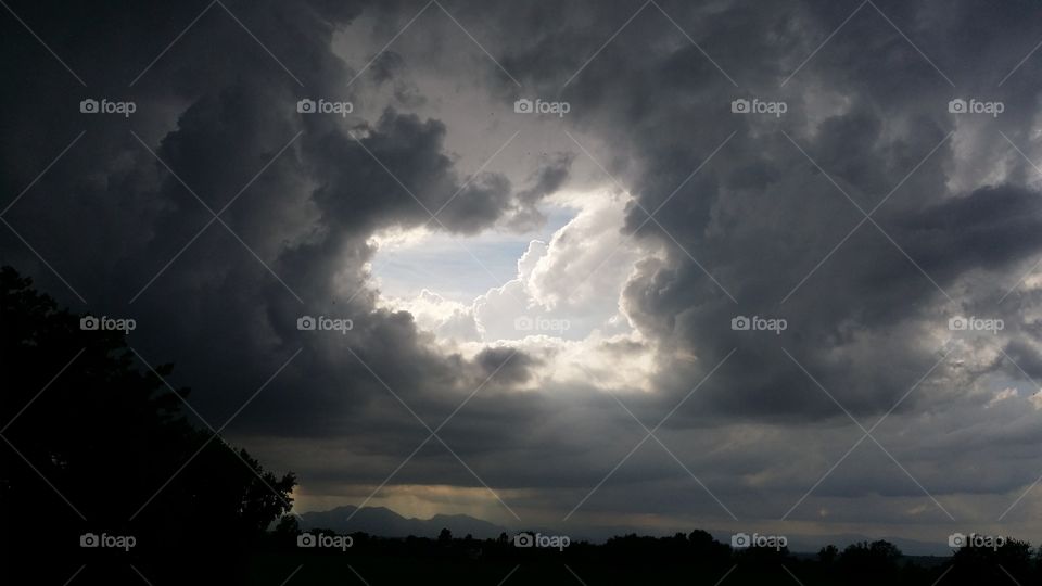 Silhouette of trees during storm clouds
