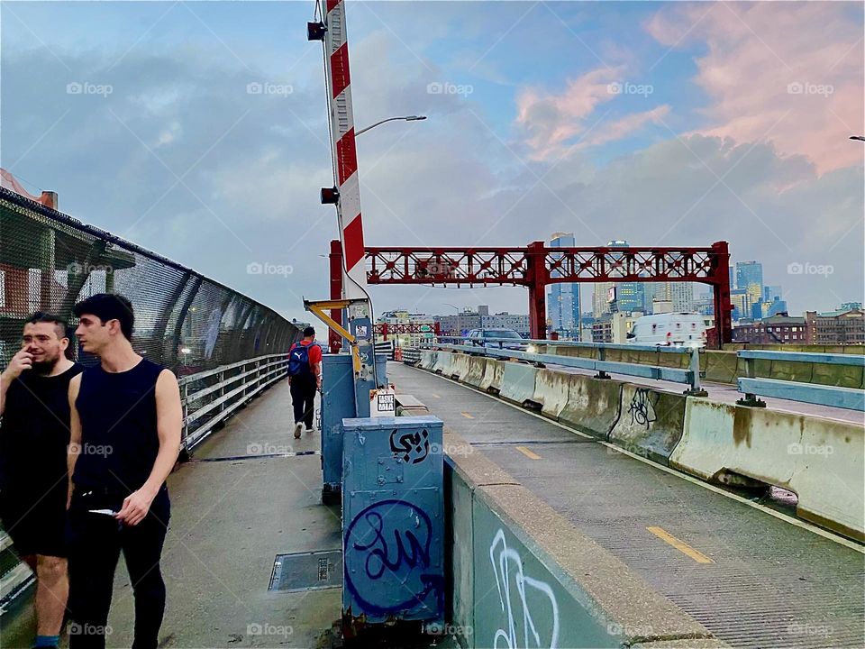 This is the pedestrian lane of the „Pulaski Bridge“ at „Newtown Creek“ that connects „Greenpoint“, Brooklyn to LIC, Queens. The sun is about to set and is leaving remnants of pink everywhere. 2023. Hypnotic Productions