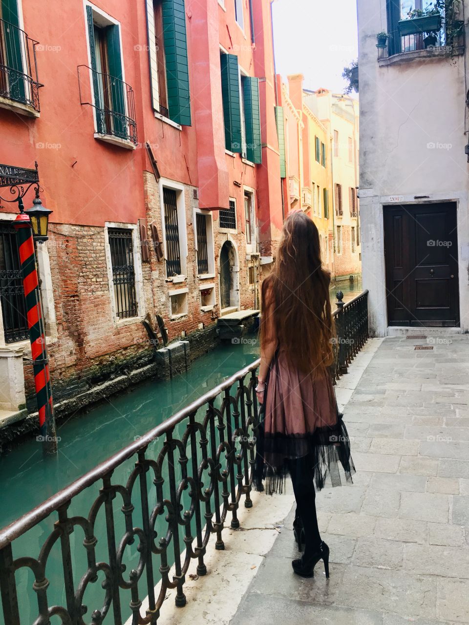 Dreaming about future in the Great city Venice Italy. Fascinating view, blue water, model, girl, evening dress, long hair, long cocktail dress. Warm bright light 🇮🇹