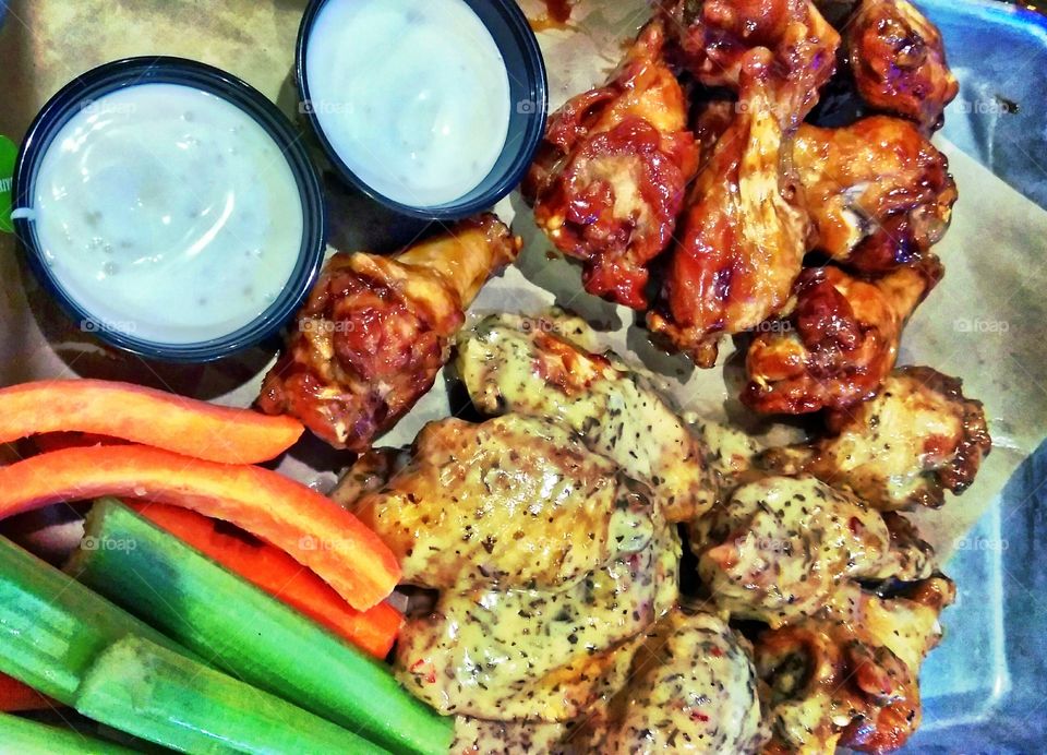 football Sunday snack, BBQ chicken wings, garlic parmesan chicken wings, celery, carrots with ranch dipping sauce