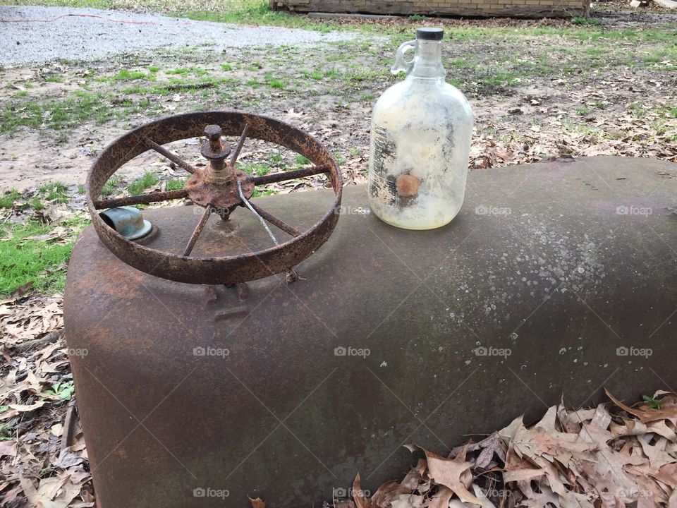 I was cleaning out my grandfather’s old chicken coop and found an old bottle and some type of wheel. I think it might be some kind of pulley.
